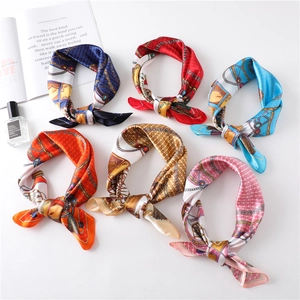 Detailed view of six silk-like square scarves with chain and carriage prints