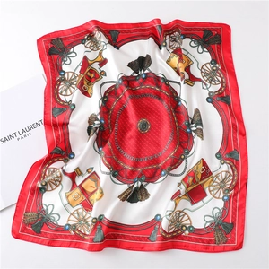 Macro shot of square satin scarf with classic red carriage and chain pattern