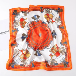 Detail of silk scarf showing orange carriage motifs and golden chain pattern