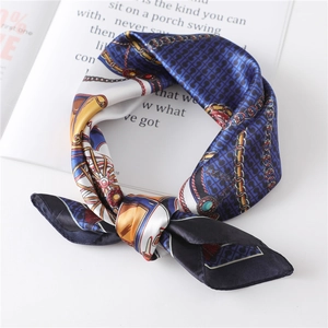 Close-up of printed satin square scarf with vintage gold chains and horse carriage motifs