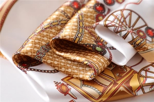 Macro shot of silk satin scarf featuring vintage golden chain and carriage print patterns
