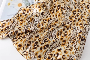 Detailed close-up of leopard print satin scarf showing smooth texture and glossy finish