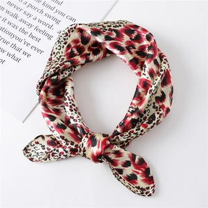 Close-up of knotted red and black leopard print satin scarf with elegant silk texture
