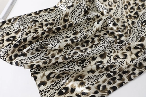 Close-up of leopard print satin fabric showing silky texture and hemmed edges