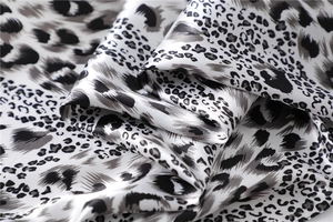 Detail view of leopard print satin scarf featuring black and white silky smooth fabric texture