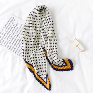 Vue détaillée du foulard en soie plissé à pois bleu marine et bordure géométrique