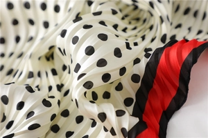 Vue rapprochée d'un foulard plissé à pois noirs avec des bordures rouges contrastées