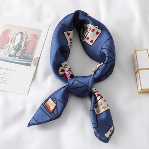 Detail of navy silk scarf with vintage poker heart pattern on a white fabric backdrop
