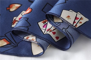 Detail of navy blue satin scarf featuring heart poker card patterns and fine stitching