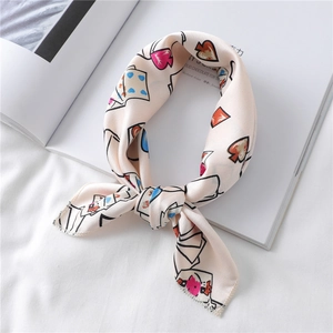 Close-up of heart and poker pattern silk scarf tied on white fabric and magazine