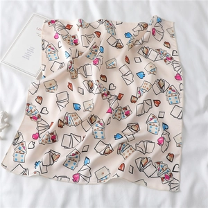 Detail of a 50x50cm satin scarf with heart and poker card patterns on a white background