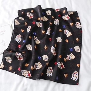 Detailed view of black satin scarf with heart and playing card patterns on white fabric