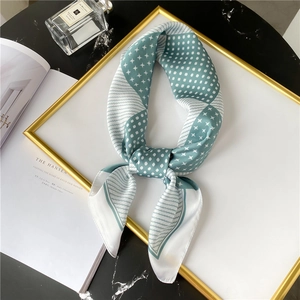 Geometric mint green and white silk square scarf with polka dots and stripes on marble