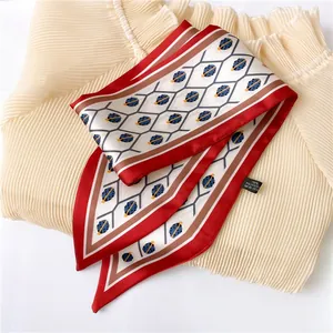 Close-up of red and white twilly scarf with ladybug print and 100% polyester label