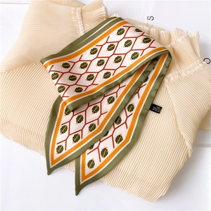 Detail of double-sided polyester silk scarf with orange geometric honeycomb pattern