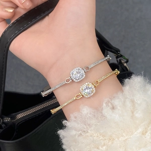 Macro detail of gold and silver bracelets with square cut cubic zirconia halo setting