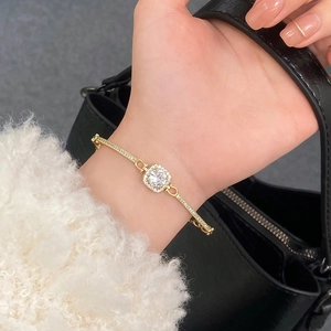 Macro detail of gold-plated square cubic zirconia bracelet featuring halo setting stones
