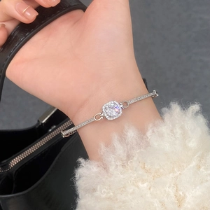 Close-up of sparkling square zircon bracelet with halo setting worn by a woman