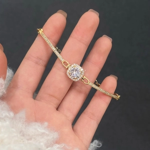 Macro shot of gold-plated bracelet with square-cut sugar zircon and pavé setting details