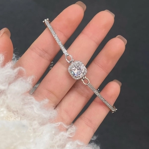 Close-up of shimmering silver halo zircon bracelet with round center stone on wrist