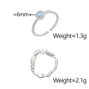 Detailed view of silver rings featuring blue cat-eye stone and irregular wave pattern
