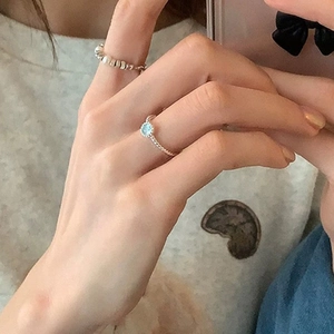 Detailed shot of twisted silver band ring featuring a light blue round cat-eye stone