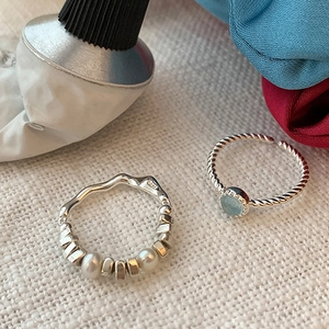 Detail of S925 silver rings with blue cat eye gemstone and irregular pearl design