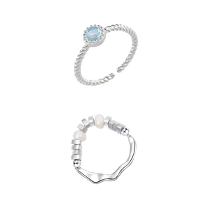 Elegant silver-tone rings featuring light blue gemstone and pearls on white background