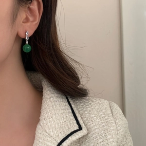 Detailed view of silver drop earrings with micro-set zircon and round green chalcedony stone