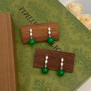 Elegant green chalcedony drop earrings with zircon inlays on a vintage wood base