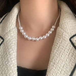 Gros plan d'un collier de perles blanches élégantes avec dégradé sur un mannequin