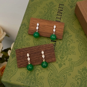 Detailed view of green chalcedony drop earrings with micro-inlaid zircon in gold and silver