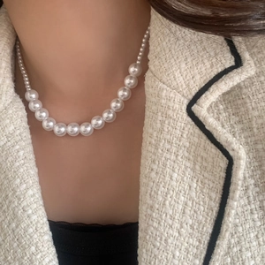 Collier élégant en perles blanches dégradées avec des perles brillantes sur un mannequin