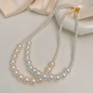 Détail d'un collier de perles à deux rangs avec perles dégradées et fermoir doré