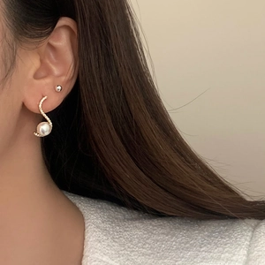 Elegant gold curved stud earrings with micro-pave zircons and white Mabe pearls