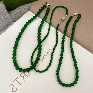 Macro view of green chalcedony beaded necklaces with silver clasps in two bead sizes