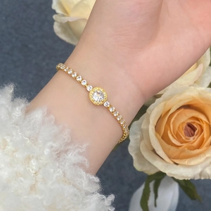 Detail of adjustable gold zircon bracelet with circular crystals on a woman's wrist