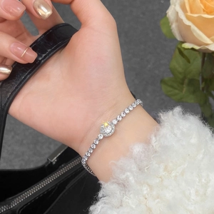 Close-up of a silver adjustable zircon bracelet with a halo centerpiece on a wrist