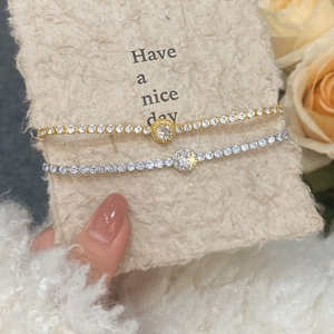 Close-up of gold and silver tennis bracelets with micro-pave zircons and center stones