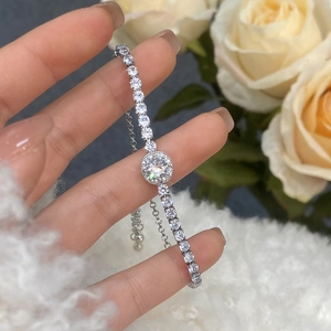Close-up of adjustable silver tennis bracelet with pavé cubic zirconia and ball charm