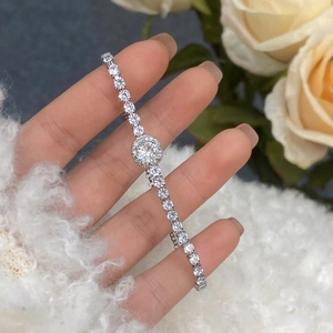 Detailed close-up of micro-pave zircon tennis bracelet with adjustable silver chain link