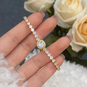 Close-up of elegant gold tennis bracelet with central round zircon on a person's wrist