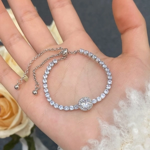 Close-up of silver tennis bracelet with cubic zirconia halo stone and adjustable slide clasp