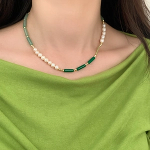 Detail of natural pearls and green stone beads on an elegant gold accent bracelet