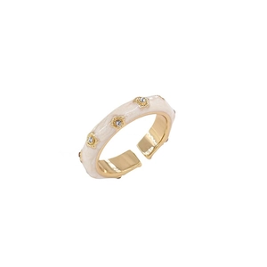 Adjustable gold ring with cream enamel and star-shaped zircon stones on white background