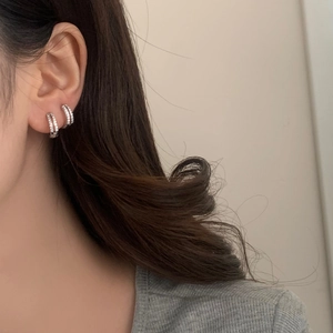 Minimalist silver hoop earrings with micro-inlaid cubic zirconia on model's ear