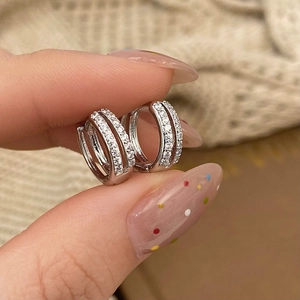 Macro view of silver double-layered huggie earrings with micro-pave cubic zirconia crystals