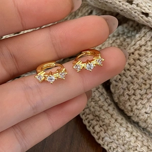 Detailed view of gold plated hoop earrings featuring three sparkling zircon stones