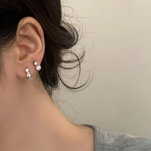 Elegant silver-tone earrings with three gradient zircons on a model side profile