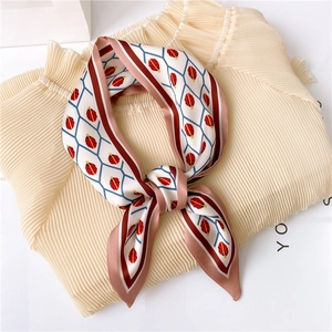 Silk-like long scarf with red ladybug and geometric print tied on a pleated blouse